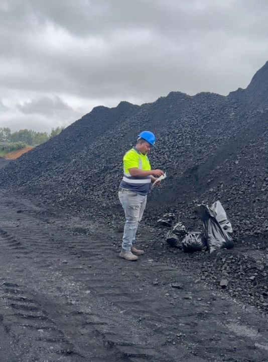 G8 quality controller checking a coal sample on site